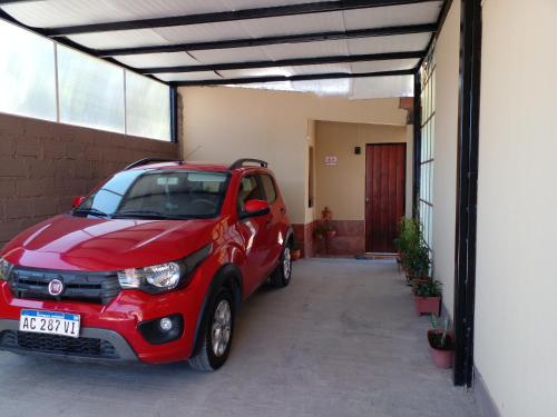 a small red car parked in a garage at La casita de abu! in Salta