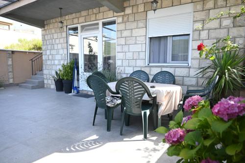 a patio with a table and chairs and flowers at Đuričić Apartmani in Budva