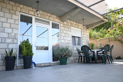 a patio with a table and chairs in front of a door at Đuričić Apartmani in Budva