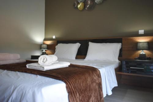 um quarto com uma cama grande e toalhas em VIRGIN ROCKs APARTMENT 2 em Kalabaka