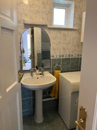 a bathroom with a sink and a mirror at The Beach House in Lahinch