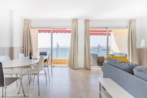sala de estar con sofá, mesa y sillas en Piso en primera linea con vistas directas al mar, en Melenara
