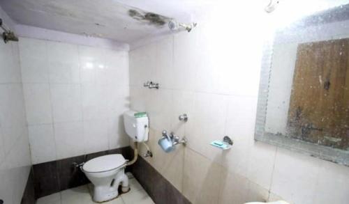 uma casa de banho suja com um WC e uma janela em New Agra Guest House By WB Inn em Agra