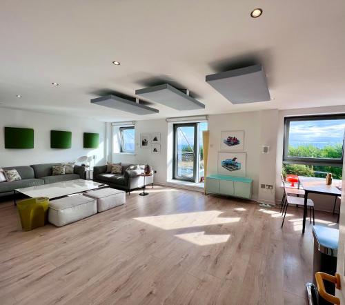 a living room with a couch and a table at Beautiful modern sea-side apartment in the city in Edinburgh