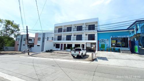 マニラにあるThe Palines Aparthotel near Palazzo Verde Evia Alabangの建物の前に駐車された白い車