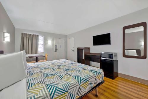 a hotel room with a bed and a mirror at Motel 6-Plano, TX - Plano Northeast in Plano