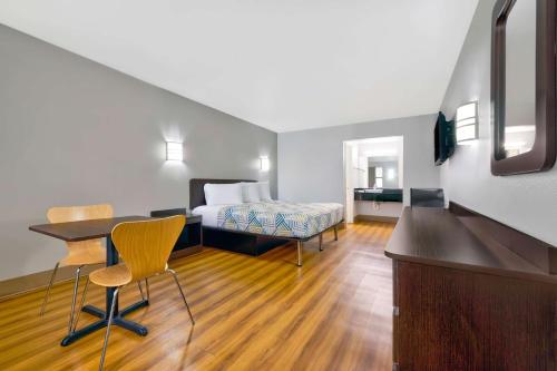 um quarto de hotel com uma cama, uma secretária e cadeiras em Motel 6-Plano, TX - Plano Northeast em Plano