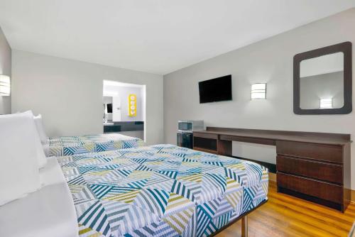 a bedroom with a bed and a desk and a mirror at Motel 6-Plano, TX - Plano Northeast in Plano