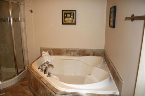 a bath tub in a bathroom with a shower at Relais St-Denis in Saint-Sauveur-des-Monts