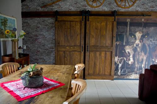 a dining room with a wooden table with chairs at De Deel - Vakantiehuisje Veluwe in Ede