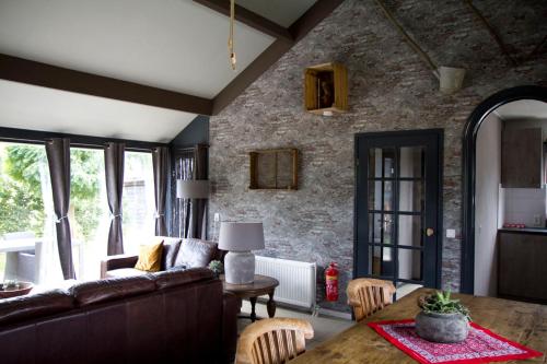 a living room with a couch and a table at De Deel - Vakantiehuisje Veluwe in Ede