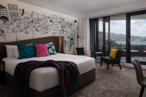 um quarto de hotel com uma cama e uma grande janela em QT Wellington em Wellington