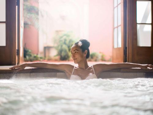 a woman in a hot tub in a building at Fairmont Grand Del Mar in San Diego