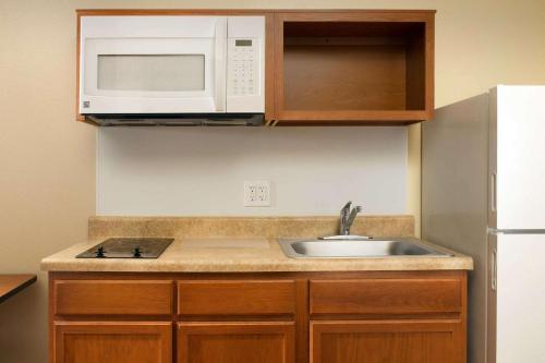a kitchen with a sink and a microwave at WoodSpring Suites Louisville Jeffersontown in Louisville