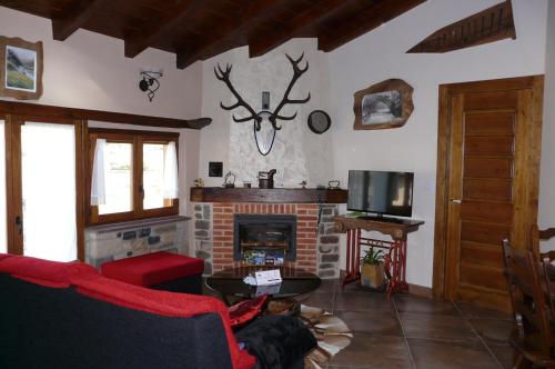 a living room with a fireplace and a red couch at Apartamentos La Condesa in Valmeo
