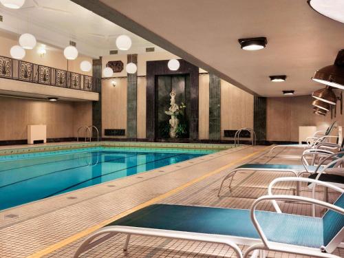 a swimming pool with chairs and tables in it at Fairmont Chateau Laurier in Ottawa