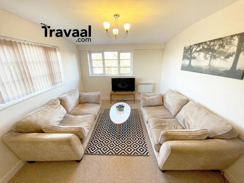 a living room with two couches and a tv at Travaal.©om - 2 Bed Serviced Apartment Farnborough in Farnborough