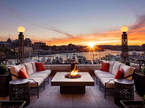 a patio with a fire pit with a view of a harbor at Fairmont Empress Hotel in Victoria