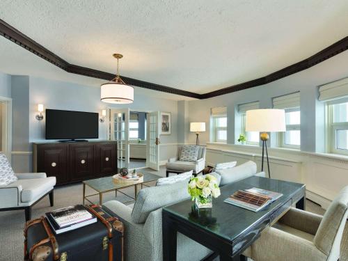 a living room with a couch and a tv at Fairmont Le Chateau Frontenac in Quebec City