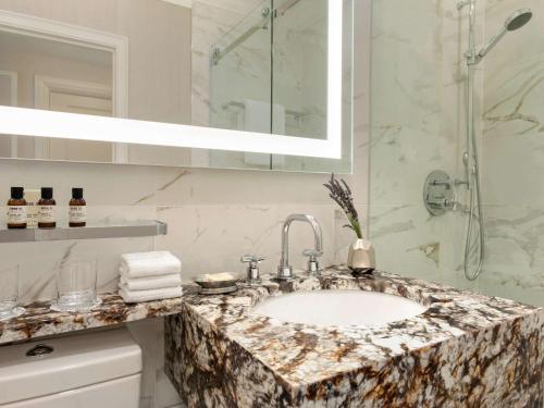 a bathroom with a sink and a mirror at Fairmont Hotel Vancouver in Vancouver