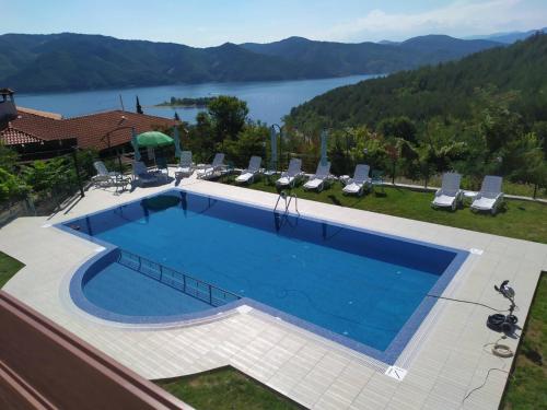 a large swimming pool with a view of a lake at Вила БОЛЯРКА - РЕЛАКС in Glavatartsi