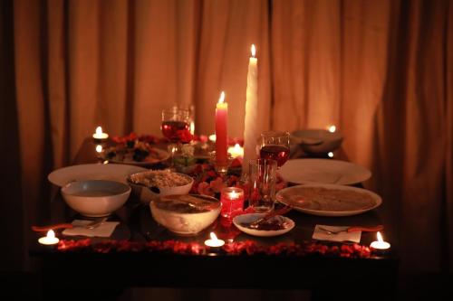 a table with plates and bowls of food and candles at Paadi Holidays Ramakkalmedu in Idukki