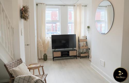 a living room with a flat screen tv on a stand at Bee Stays - Pickmere House in Warrington