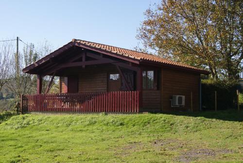 une petite maison sur une colline avec une clôture rouge dans l'établissement Chalets Etchemendigaraya, à Suhescun
