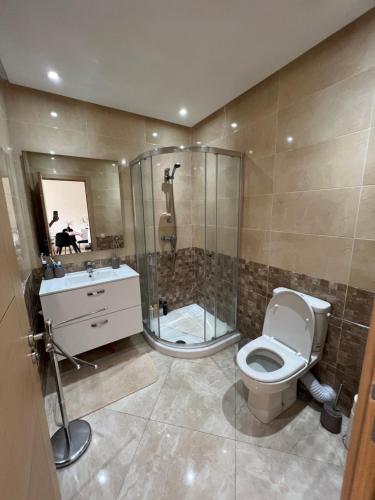 y baño con ducha, aseo y lavamanos. en Résidence RAMOFLORES - Appartement avec piscine - Sidi Rahal, en Sidi Rahal