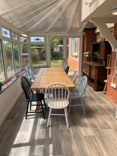 ein Esszimmer mit einem Holztisch und Stühlen in der Unterkunft Stonehenge Hostel - YHA Affliated in Amesbury