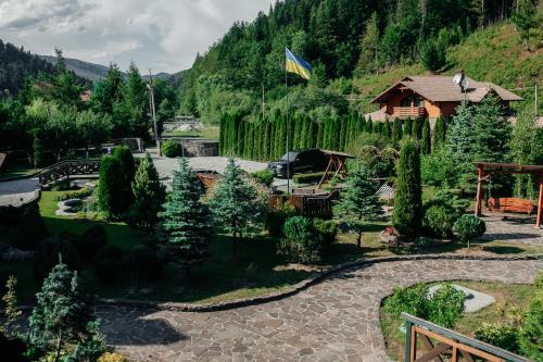 een uitzicht op een tuin met een huis en een vlag bij Готель Жди ня Єво instagram zhdenievo hotel in Zhdenievo