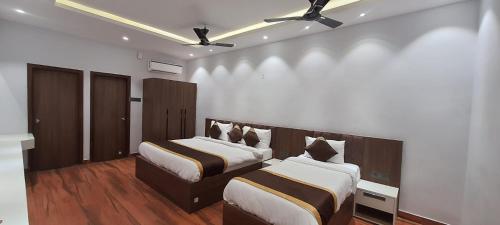 Un dormitorio con dos camas y un ventilador de techo. en Hotel citrus, en Lucknow