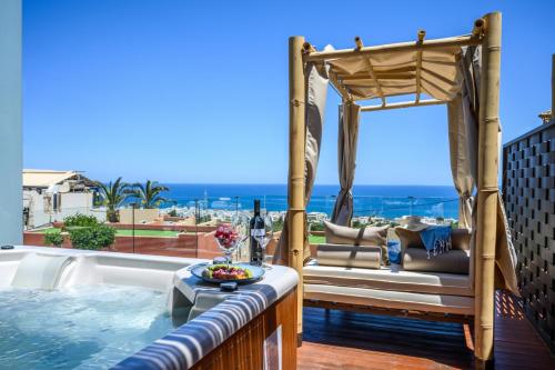 a hot tub on a balcony with a view of the ocean at Esperides Resort Crete, The Authentic Experience in Hersonissos