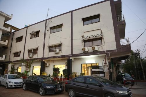 three cars parked in front of a building at Green Club Farm in Ajmer