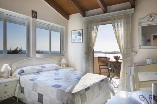 a bedroom with a bed with a view of the ocean at Panorama Fanari studios and apartments in Argostoli