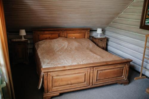 a bedroom with a wooden bed with two night stands at Готель Жди ня Єво instagram zhdenievo hotel in Zhdenievo
