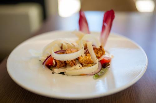 a white plate with food on a table at Hostellerie Saint Vincent Beauvais Aeroport in Beauvais