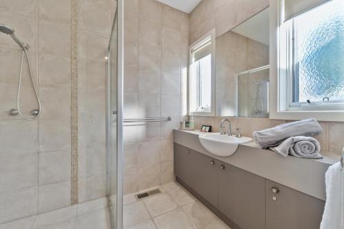 a bathroom with a sink and a shower at Seaford Luxe Beach House 2023 BDC Traveller award winner in Seaford
