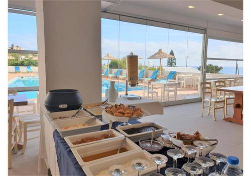 een tafel met eten erop met uitzicht op een zwembad bij Saradari Beach Hotel - Adults Only in Chersonissos