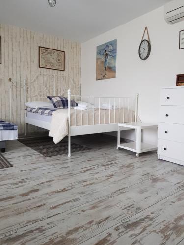 a bedroom with a white bed and a white dresser at Seaside in Gdańsk