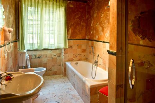 a bathroom with a tub and a toilet and a sink at Suite Accommodation in Lucca