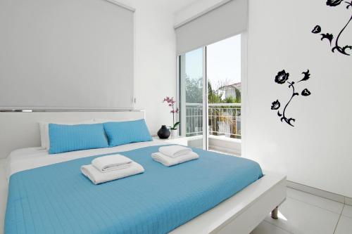 a bedroom with a blue and white bed with two pillows at Villa Paloma in Paralimni
