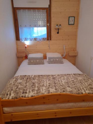 une chambre avec un grand lit avec une fenêtre dans l'établissement Les Pierres Blanches 2 pieces cosy et fonctionnel, aux Contamines-Montjoie