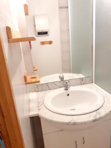 a white bathroom with a sink and a shower at Les Pierres Blanches 2 pieces cosy et fonctionnel in Les Contamines-Montjoie