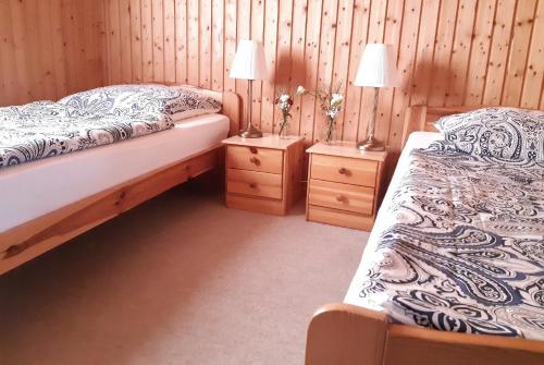 a bedroom with two beds and two night stands at Landhof Kützin Ferienhaus 6 Specht 