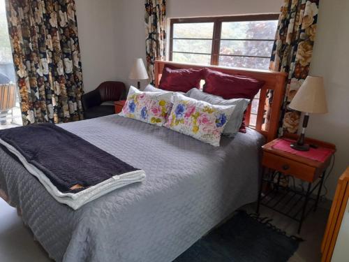 1 dormitorio con cama con almohadas y ventana en The Hideout, en Port Shepstone