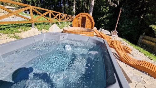 a hot tub with a table and chairs in a backyard at Aparthotel Delta Royal in Kościelisko