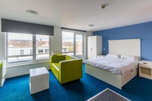 a bedroom with a bed and a yellow chair at Destiny Student – Murano (Campus Accommodation) in Edinburgh