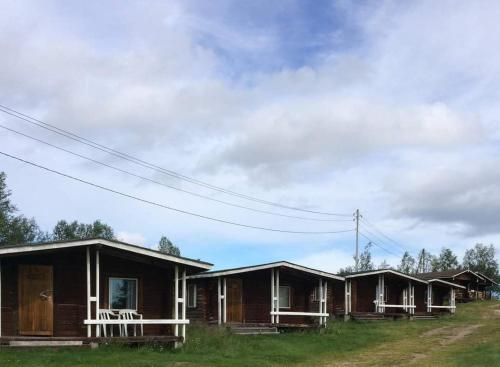 una fila di cottage sul lato di un campo di Lätasenonmajat a Enontekiö