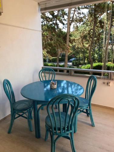 una mesa azul y sillas en un patio en TARTANA, en Lignano Sabbiadoro